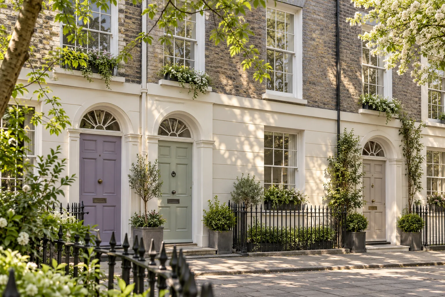 Brick-and-stucco terrace with lilac, celadon and putty doors beneath arched fanlights